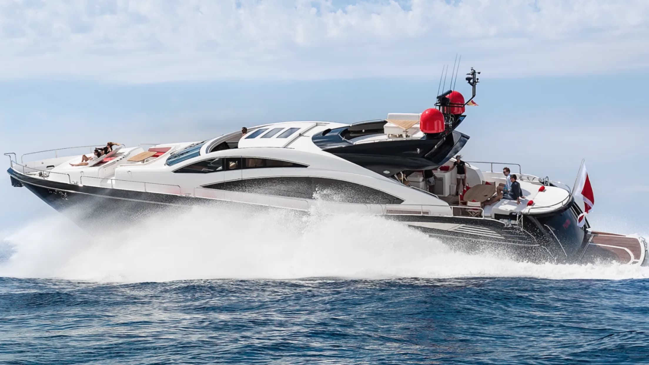A sports superyacht running at speed through open water off Ibiza, guests on deck