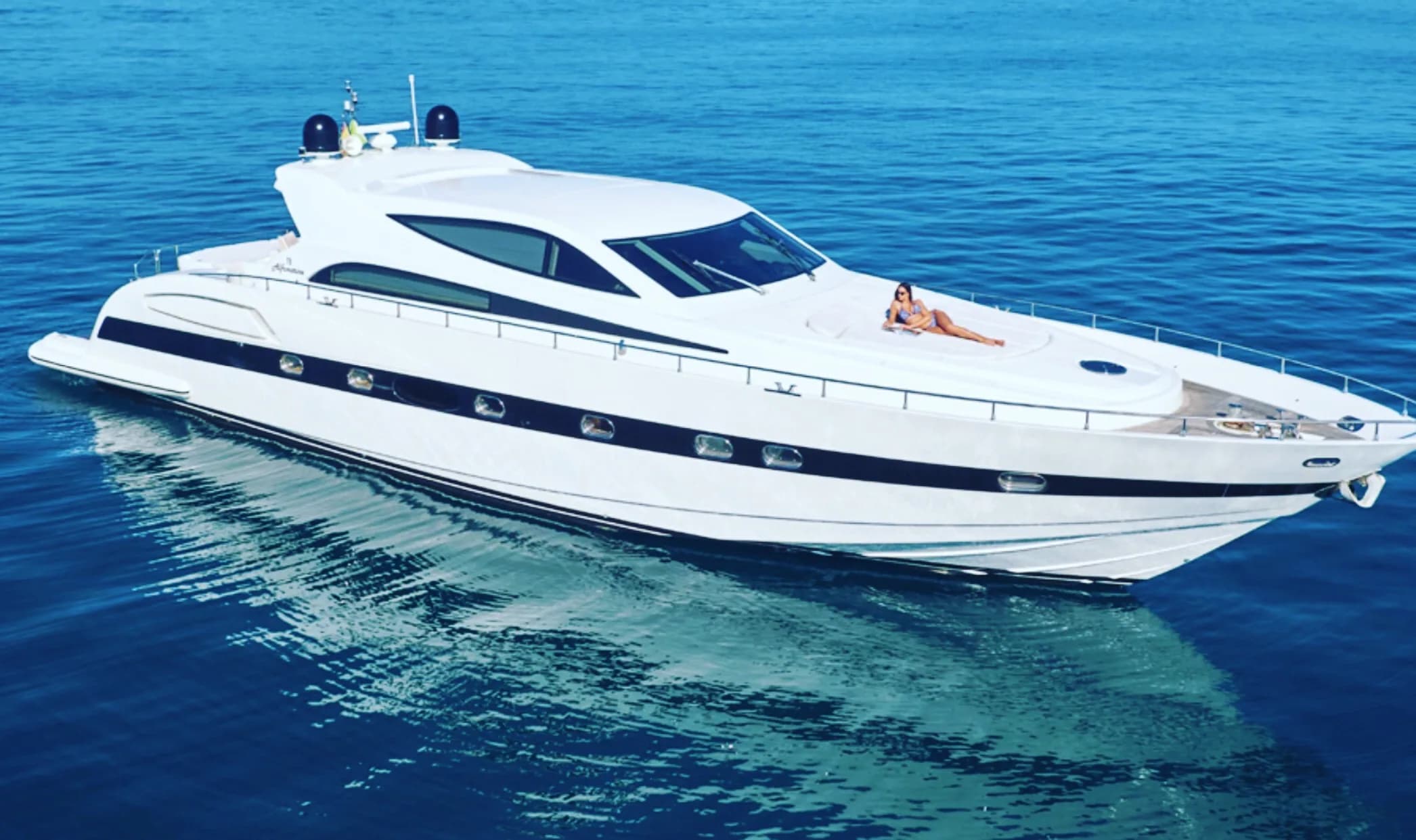 A large motor yacht lying at anchor in deep blue water off Ibiza